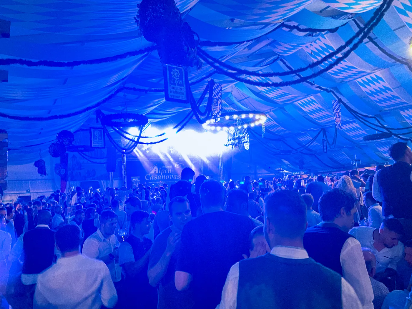 Blick von der Bühne auf das Publikum im blau beleuchteten Festzelt