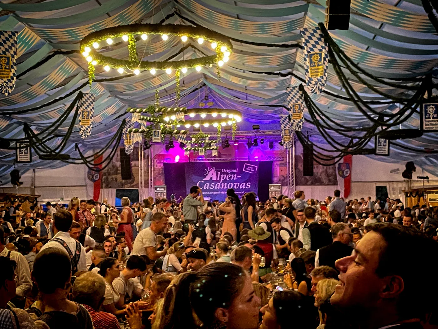 Gäste im Festzelt vor der blau beleuchteten Bühne