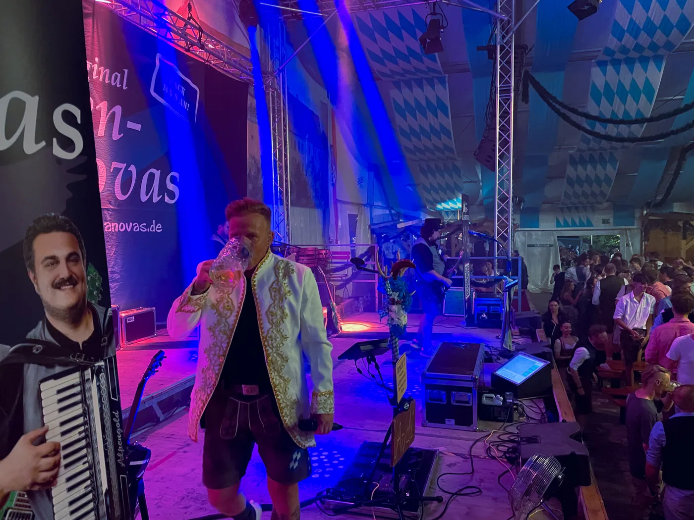 Sänger der Original Alpencasanovas auf der beleuchteten Festzeltbühne