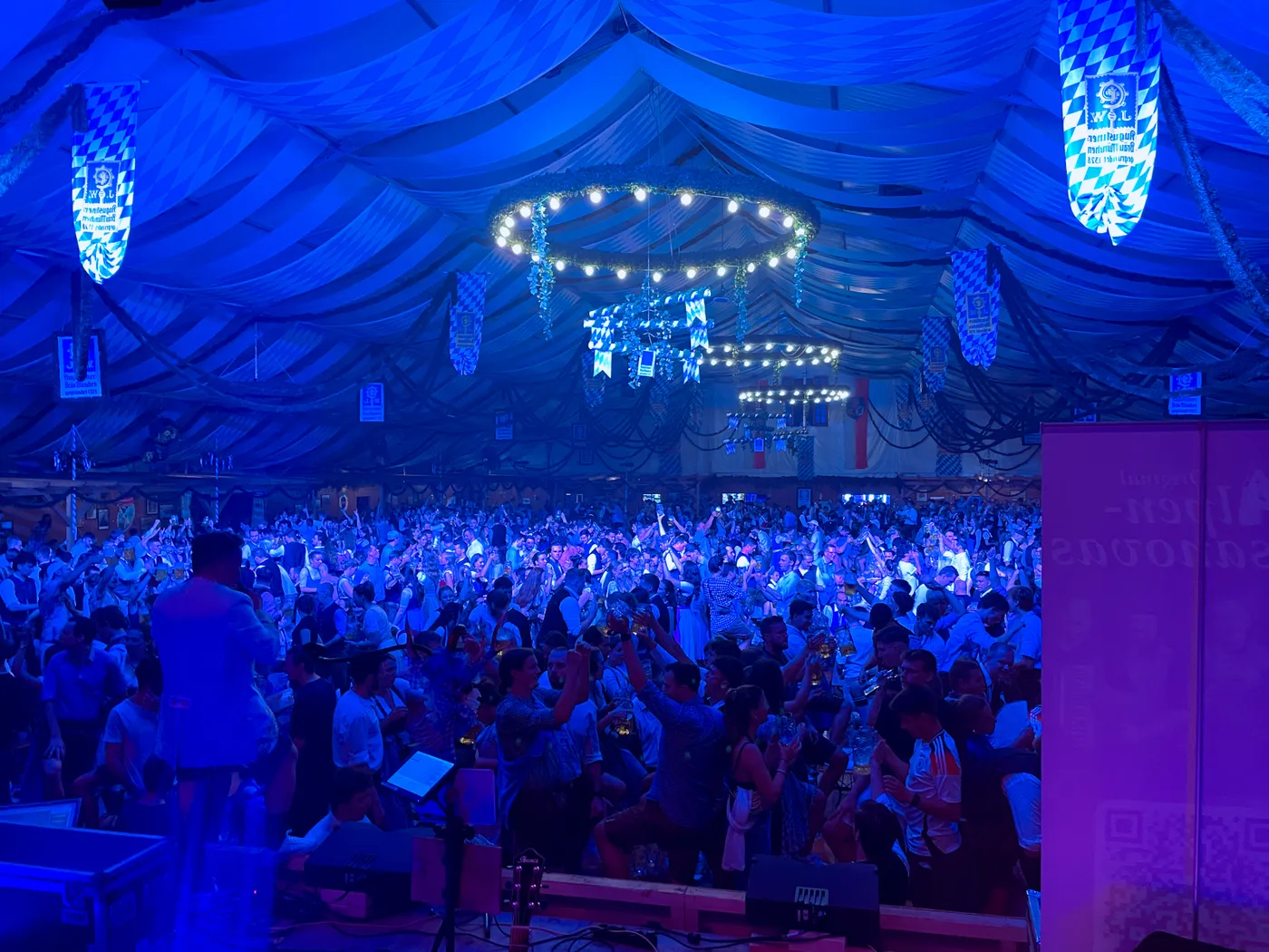 Volles Festzelt vor der blau beleuchteten Bühne