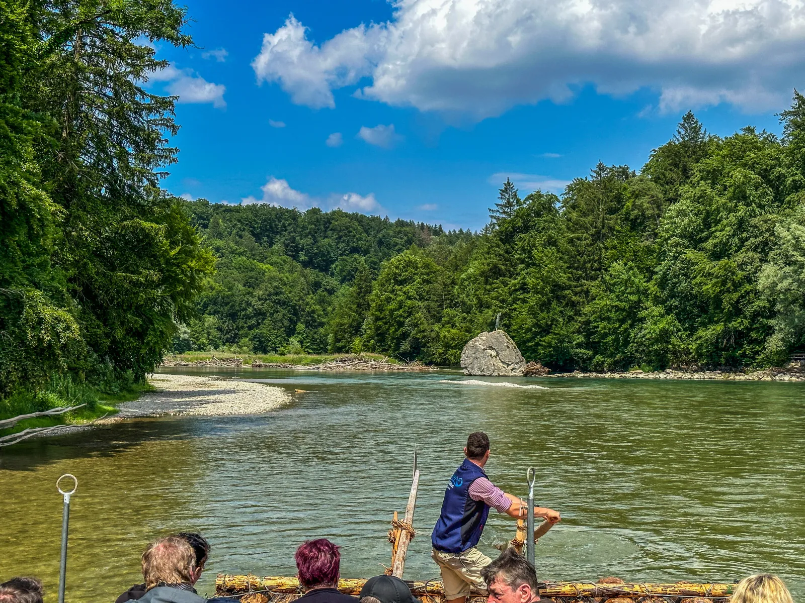 Gäste und Floßführer auf einer Floßfahrt auf der Isar