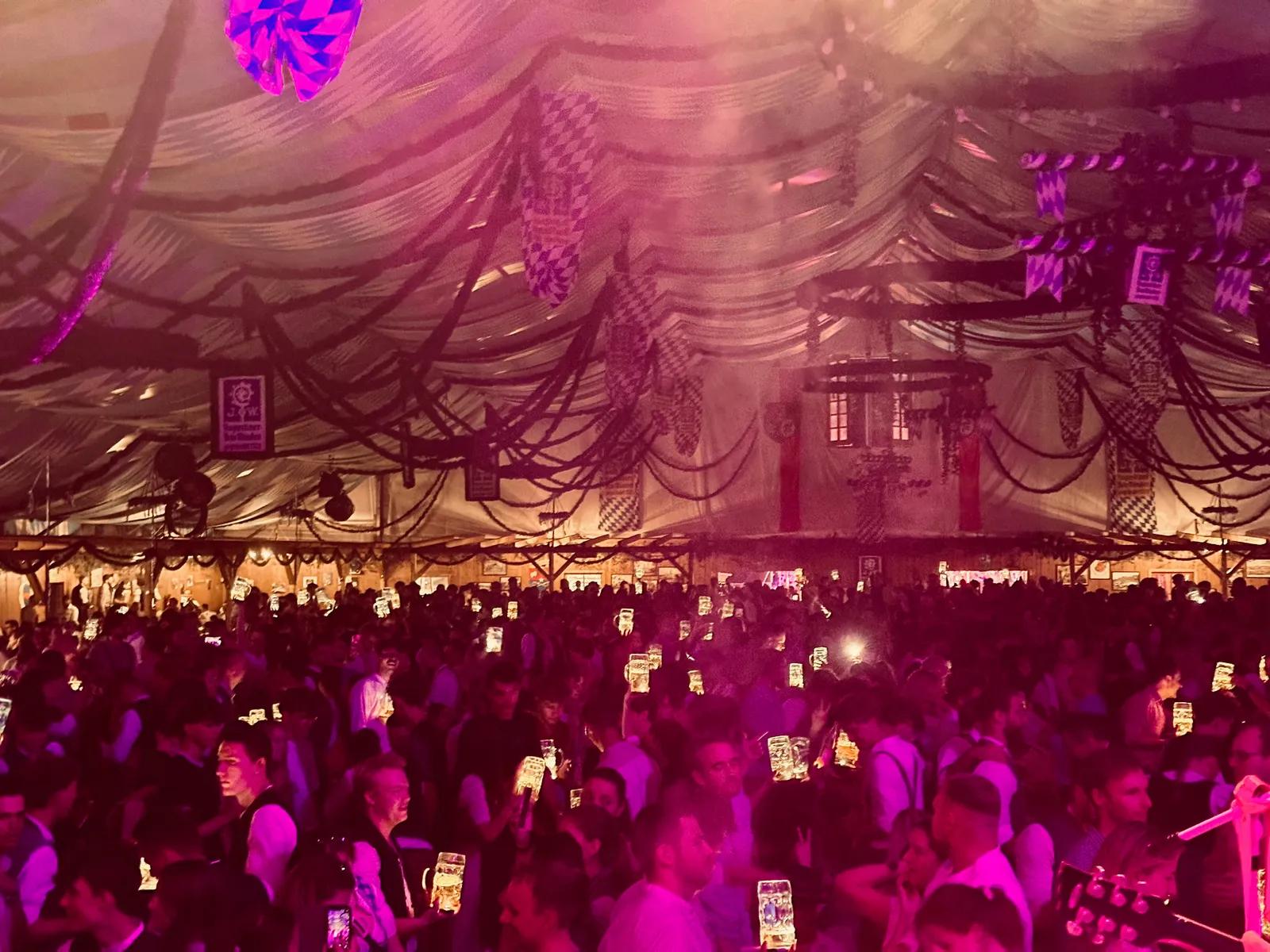 Publikum mit Bierkrügen bei einem Partyabend im Festzelt